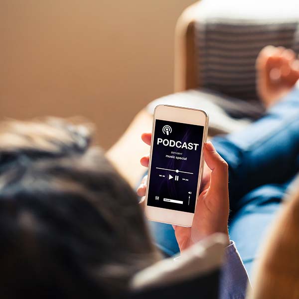 Stock photo of person looking at podcast on smart phone