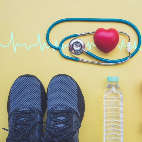 A photo of a pair of sneakers, a bottle of water, and a stethoscope on a yellow background. There is also a heartbeat line.
